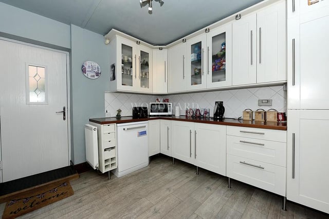It might be an irregular shape, but for style and amenities, the kitchen can hardly be faulted. With its laminate wood flooring, it boasts a range of wall and base units with rolled-top work surfaces and tiled splashbacks. An integrated fridge freezer is a bonus, while a door leads out to the side of the house.