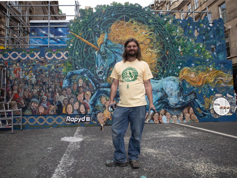 As New Year 2023 approached, mural artist Chris Rutterford brightened up some of the hoardings with his painting of Hogmanay crowds gathering at the nearby Tron Kirk. He had originally painted the mural in 2013, but added a spectacular unicorn for its reappearance.