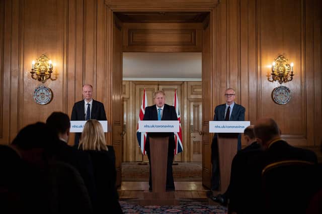 Chief Medical Officer Chris Whitty (L) and Chief Scientific Adviser Patrick Vallance (R) look on as Britain's Prime Minister Boris Johnson addresses a news conference (Photo by Leon Neal / POOL / AFP) (Photo by LEON NEAL/POOL/AFP via Getty Images)