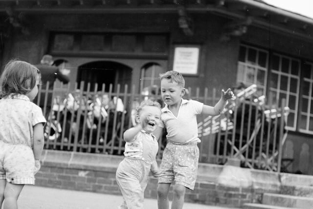 Two little boys dance to a band in Inverleith Park in August 1963.