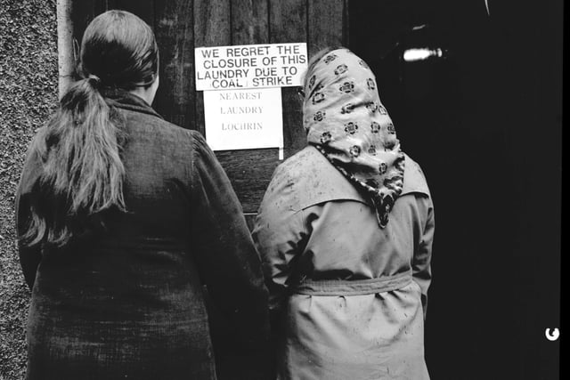 Two women read the 'closed' notice on the door of the Causewayside public laundry  - the steamie - in Edinburgh.