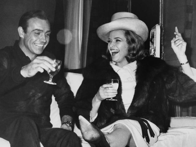 Scottish actor Sean Connery and English actress Honor Blackman enjoy themselves during a break in filming the James Bond movie 'Goldfinger' at Pinewood Studios, UK, 25th March 1964.