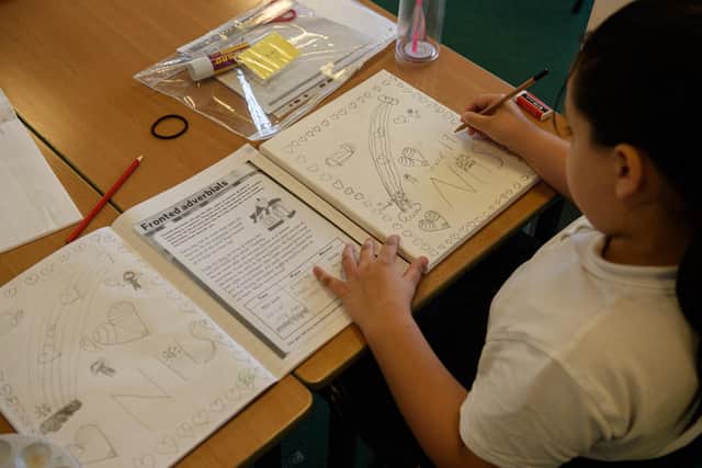 Pupils work on a task to produce artwork that depicts life during the lockdown due to the Coronavirus (Photo by OLI SCARFF/AFP via Getty Images)