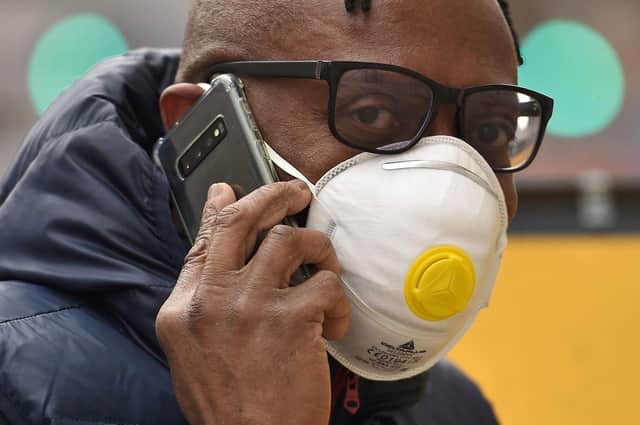A man wears an FFP2 face mask as he talks on a mobile phone