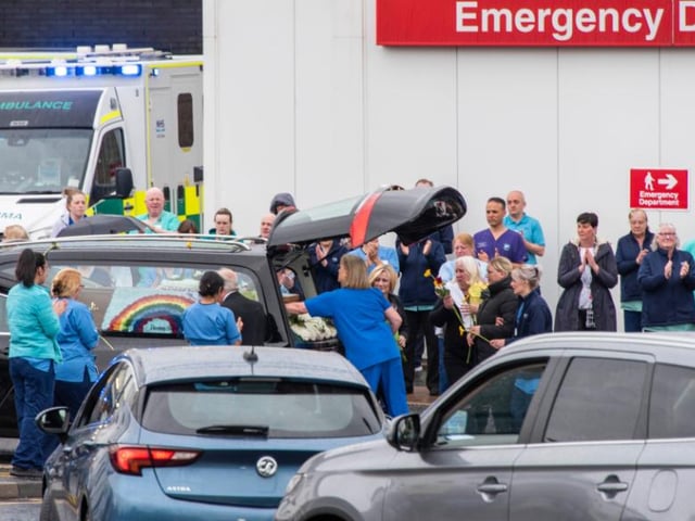 What appeared to be a rainbow floral display by the coffin was visible inside the hearse.