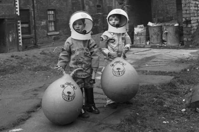 Little boys show off their Xmas presents (including astronaut suits and Space Hoppers) in Crown Street in the Gorbals area of Glasgow in December 1970.