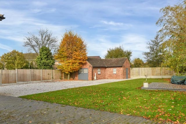 To the rear of the property there is a detached tandem garage with workshop. The remainder of the rear garden is predominantly laid to lawn and enjoys two patio areas and further established bordering.