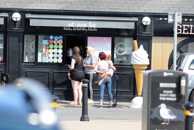 People can be seen queuing to get an ice cream as a way to cool down during the hot weather.