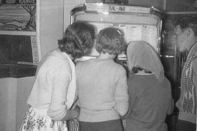 Gathered round the jukebox at South Shields fairground. Do you remember scenes like this?