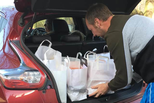 Volunteer Phil Ashford packs his car with food bags