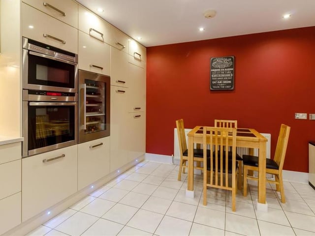 Another striking feature of the kitchen is a large larder unit and base units with pull-out shelves and two pull-out corner units. A stainless sink has a built-in drainer and pullout mixer taps, while an integrated Neff four-ring induction hob has a stainless steel extractor hood over.