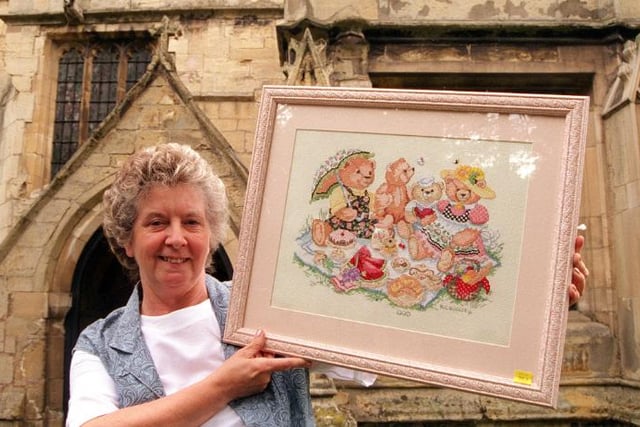 Marie Woolley outside Hickelton church with her embroidery work, 1996.