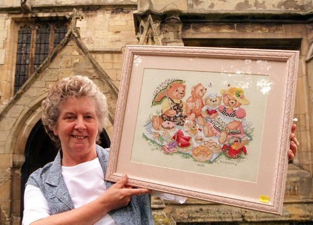 Marie Woolley outside Hickelton church with her embroidery work, 1996.