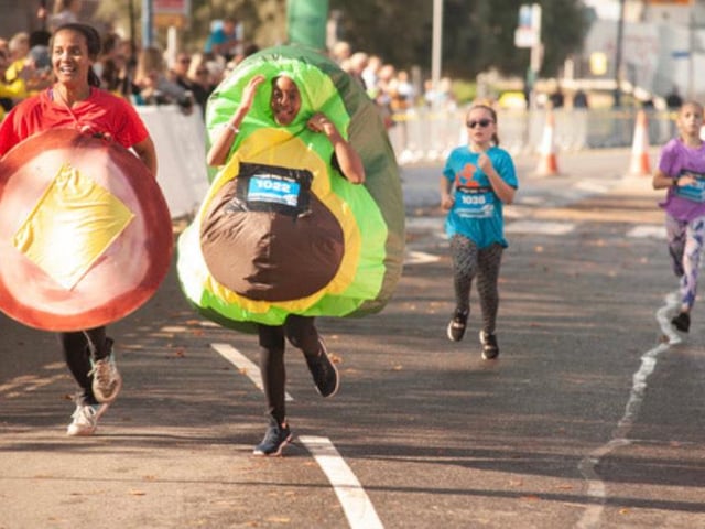 A team of runners in the junior girls race cross the finishing line - dressed as ham and cheese and a sliced avocado. Photo: Gary Tiller