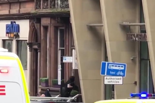 Armed police pictured entering a building in West George Street as residents are evacuated