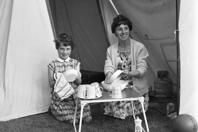 A mum and daughter wash the dishes outside their tent at the Granton campsite on Marine Drive in July 1966.