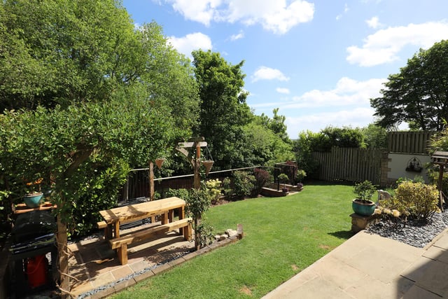 The landscaped garden has areas for seating and the lawns overlook woodland.