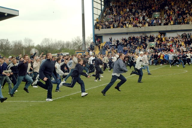 Stags fans invade the pitch to celebrate after their side beat Carlisle to clinch promotion to Division Two.