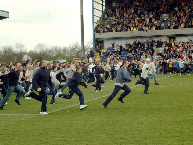 Stags fans invade the pitch to celebrate after their side beat Carlisle to clinch promotion to Division Two.