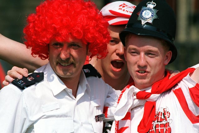 Police and  Danish Fans swop Headgear in Hillsborough Park before Euro 96 clash between Croatia and Denmark. Photo: Steve Ellis, National World