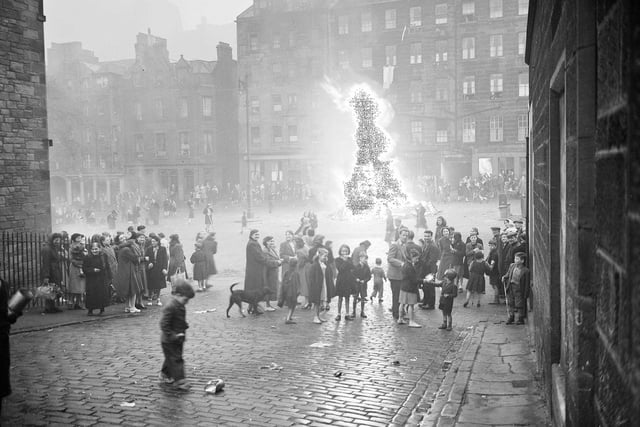 Local residents gather around a bonfire on the Grassmarket as part of celebrations to mark Victoria Day in May 1952.
