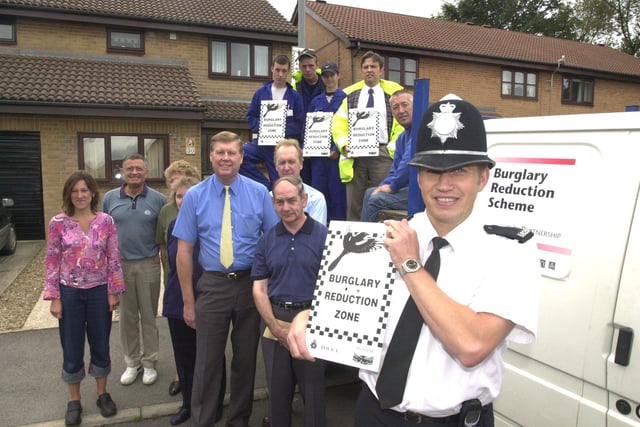 Pictured on College Close, Burngreave, where anti burglary signs were being erected, as part of the Police burglary reduction scheme in 2001. Seen  with the sign is PC Adrian  Fox the project manager, with residents and the team putting up the signs