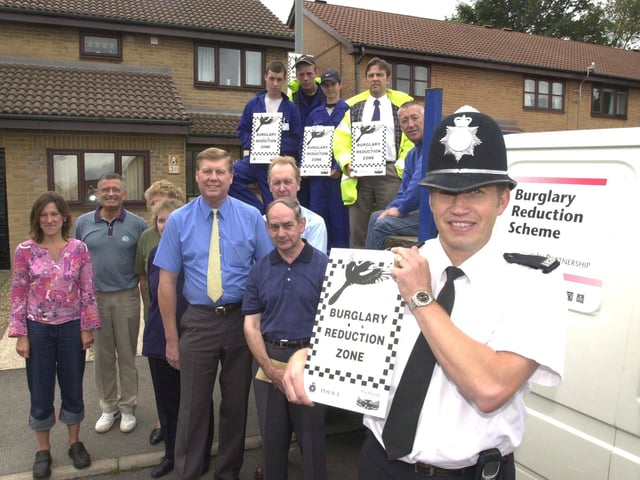 Pictured on College Close, Burngreave, where anti burglary signs were being erected, as part of the Police burglary reduction scheme in 2001. Seen with the sign is PC Adrian Fox the project manager, with residents and the team putting up the signs