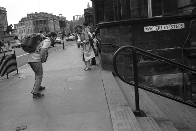Windy city: A girl laughs as her friend, with a rucksack, tries to get past Edinburgh's Waverley Steps at their junction with Princes Street during the gales of November 1981.