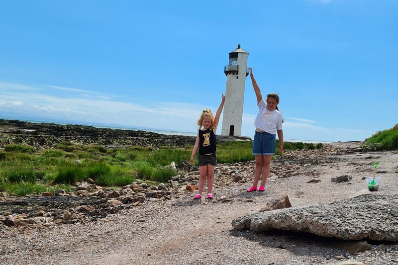 Laura Mackay took this funny picture of her children holding up an entire lighthouse.