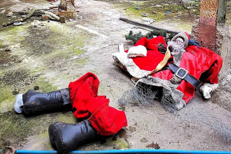 A damaged Santa Claus Christmas decoration makes a distrubing sight inside the abandoned mill.