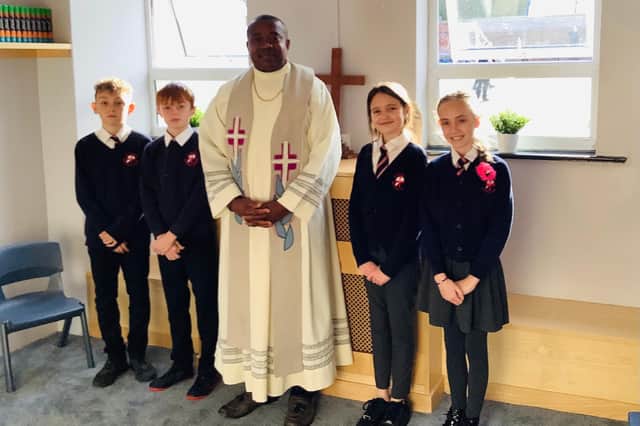 Priest Father Desmond Edozie and a group of year six pupils in the new prayer room