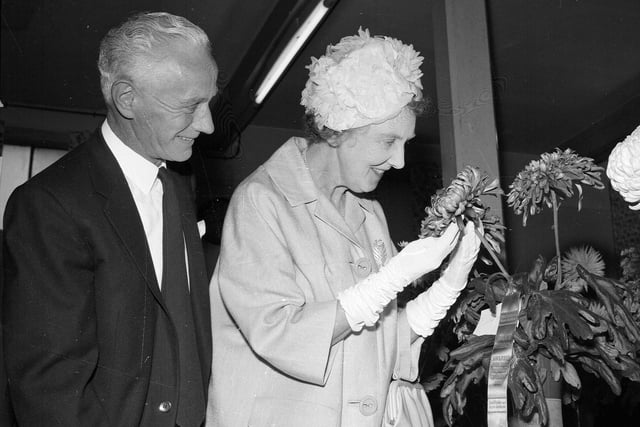 Mrs Hedderwick, the wife of a councillor, admires prize blooms with President Mr William McGregor at a flower show in Stockbridge Church Hall in September 1963.