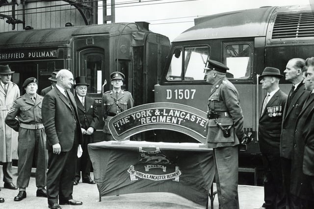 A presentation on October 22, 1964, at Sheffield Victoria Station of a locomotive nameplate to the York & Lancaster Regiment. This photo shows Mr S C Webb, British Railways divisional manager for Sheffield (left) presenting the nameplate to Brigadier G T Denaro, Colonel of the York & Lancaster Regiment (right). Also in the picture are members of the regiment and ex-servicemen of the old regiment employed by British Railways, Sheffield. In the background is the Sheffield Pullman express.