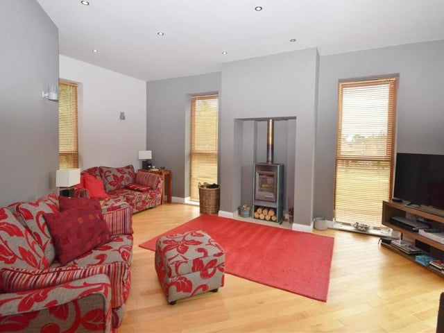 The house might be big, but this a homely lounge, complete with an impressive log-burner. There are windows to the front, side and back, while sliding pocket-doors open to the rear terrace and paved patio area.