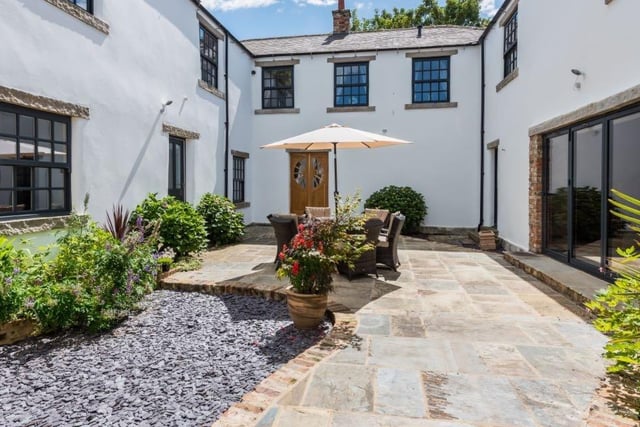 The enclosed courtyard also boasts an outdoor sitting area, which can be used for al fresco dining, while gardens and a paddock make up the approximate two acres of grounds.