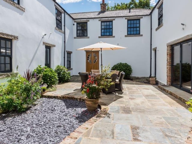 The enclosed courtyard also boasts an outdoor sitting area, which can be used for al fresco dining, while gardens and a paddock make up the approximate two acres of grounds.
