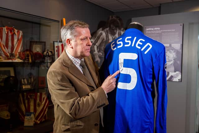 Graham Budd, auctioneer with a signed Champion League shirt worn by Chelsea footballer Michael Essien, during the season 2009/10.