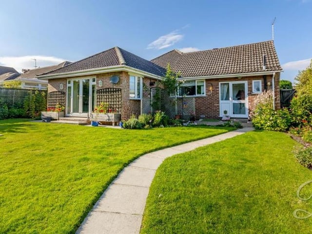 Back outside now, and a view of the property from the rear. A large lawn and a neat path keep things simple but attractive.