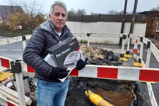 David Turner of Hanmoor Road with a Cadent-supplied electric heater at the site of the water leak on Bankfield Lane.