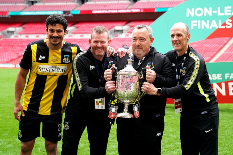 Hebburn Town manager Kevin Bolam (second right) celebrates with Angelos Eleftheriadis (left), coaches Michael Mulhern and Jason Miller (right) with the Buildbase FA Vase 2019/20 Trophy after victory in the Final at Wembley Stadium, London.