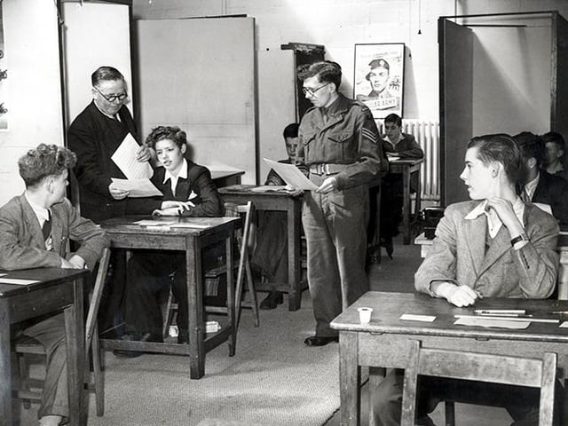 It's zero hour and the boys are taking their entrance examination for the army apprenticeship schools in Sheffield, overseen by Sgt J.A.Richardson R.A.M.C., and Chief Clerk J.Jones hands out the exam papers, in June 1953