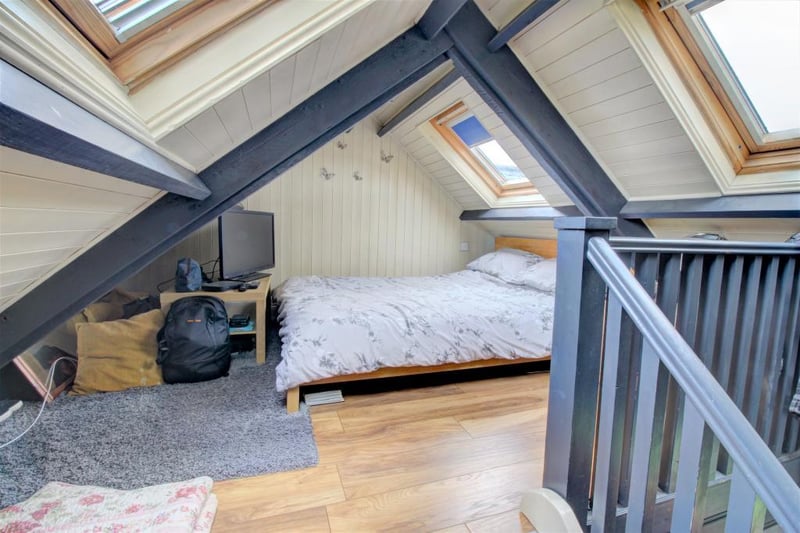 Stairs lead up to a mezzanine level which is home to the master bedroom. This is a gorgeous space with a vaulted ceiling complete with spotlights and two Velux windows for natural light
