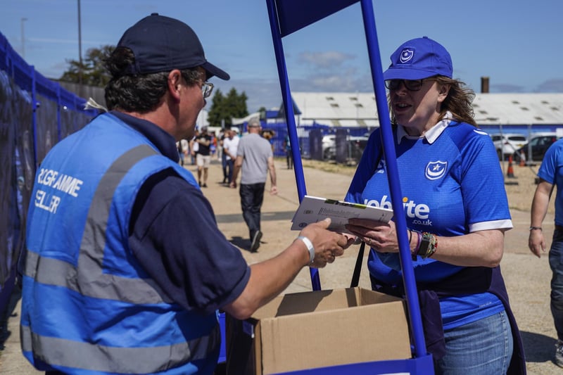 Portsmouth fan grabs a program as supporters return to Fratton Park.