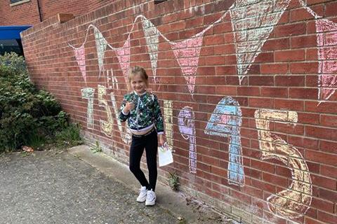 Louise Butler's daughter, eight-year-old Isla Turner, whose father served in the Army, poses in front of her fantastic chalk drawings on Honeysuckle Road in Sheffield