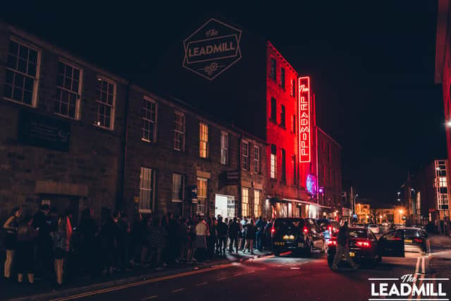 A queue outside The Leadmill in Sheffield below the red neon sign that inspired the colour of the vinyl for the 40th anniversary record