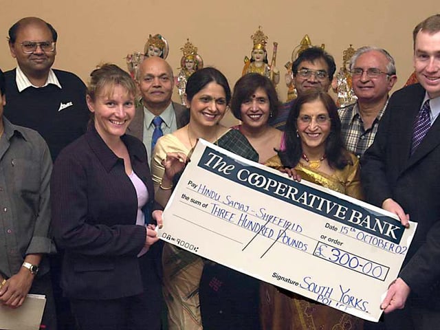 Pictured receiving a cheque for £300.00 from PC Tim Walls and Sgt Caroline Rollitt of the South Yorkshite Minorities Unit to Harsha Savani, Chairperson of HinduSamaj with Treasurer Ashwin Bha Patel and Secretaries Pushpa Venkat and Kusumben Savani with other committee members and trustees at the Ellsmere Centre Buckenham Street back in 2002