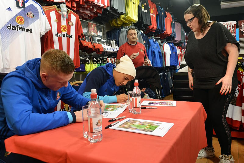 A supporter looks on as Jordan and Wahbi sign their autographs.
