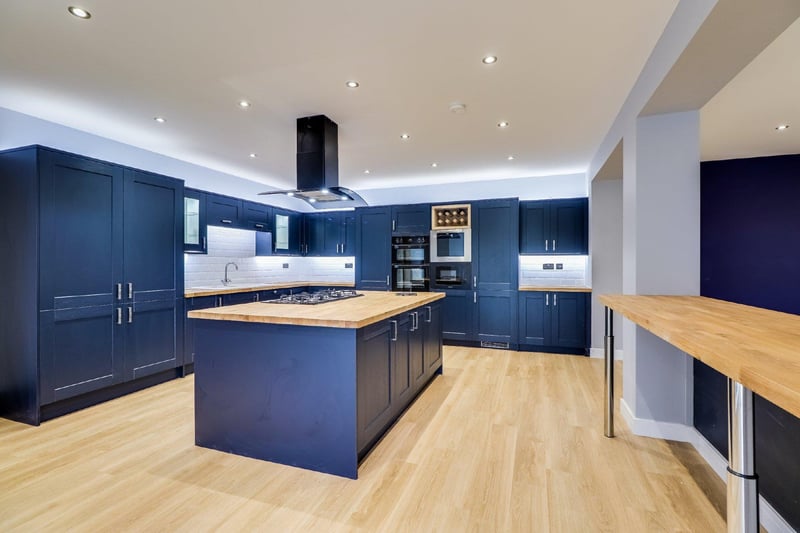 Fitted with a striking range of contemporary wall and base units with solid wood butcher's block-style worktops and brick-set tiled splash backs.