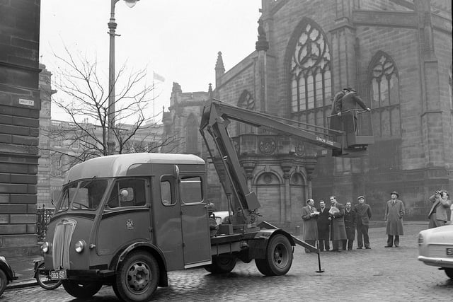 Edinburgh Corporation's Lighting and Cleansing Department are pictured testing a new hydraulic platform designed for repairing street lights at Mercat Cross in 1960.