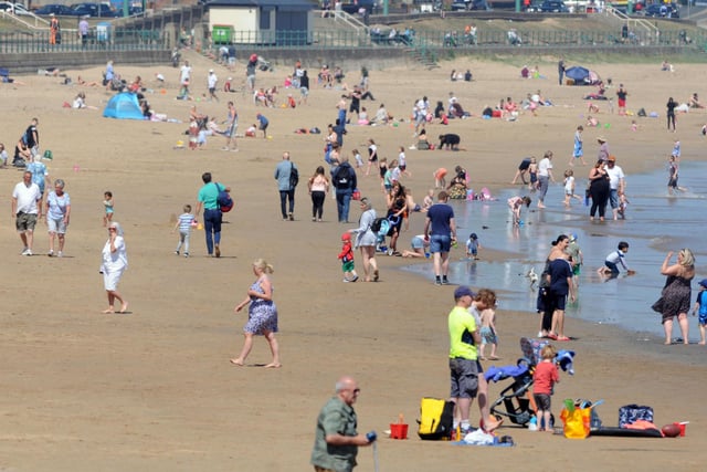 Crowds can be pictured socially distancing while enjoying the warm weather.